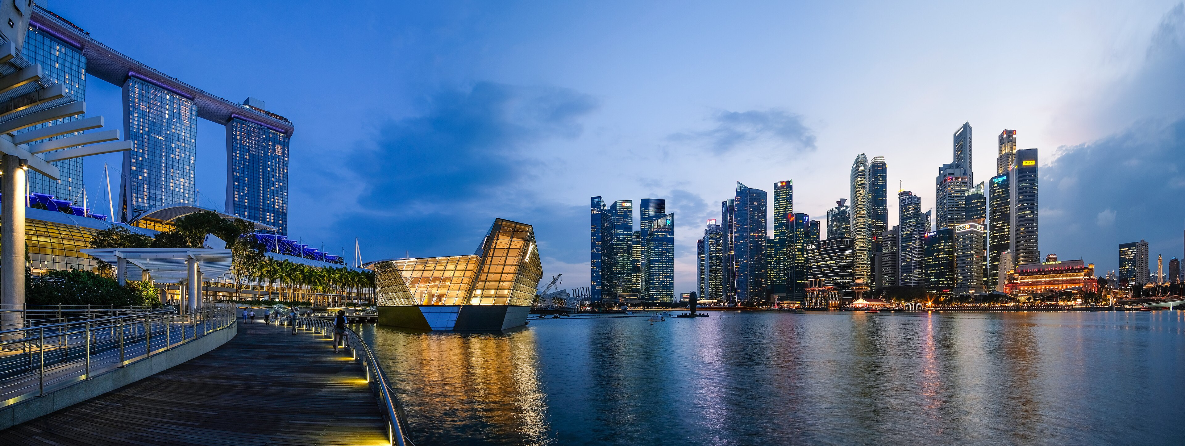 Panoramic view of the Singapore skyline at dusk — Marina Bay Sands, the ArtScience Museum, the Helix Bridge, the Esplanade theatres, and the CBD towers along Marina Bay