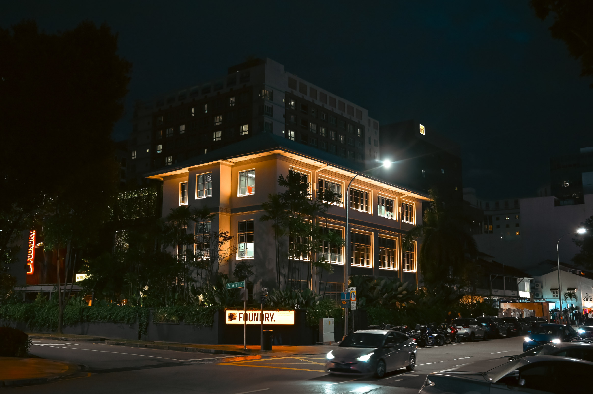 The Foundry at 11 Prinsep Link, Singapore — the restored former Elections Department building lit up at night with the FOUNDRY signage on the corner